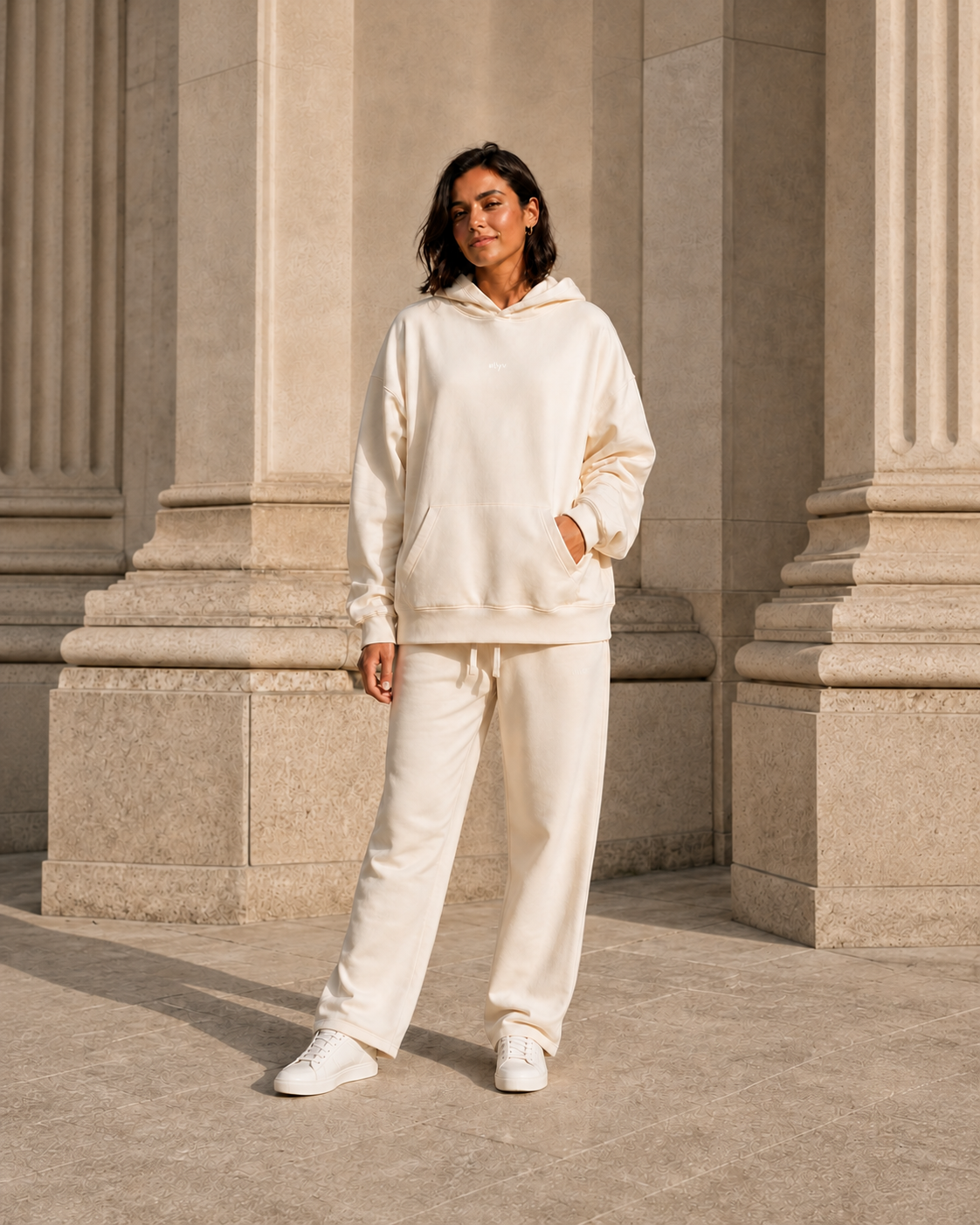 Adult model in the ULYV Cream matching hoodie and sweatpants, full length view