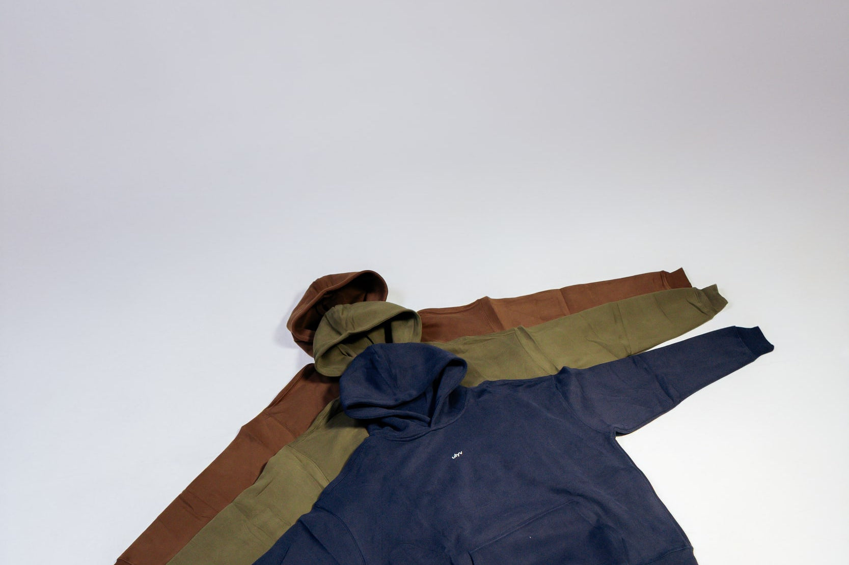 ULYV essential hoodies arranged in navy olive and brown