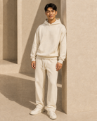 Cream ULYV matching hoodie and sweatpants on an adult male model, full length view