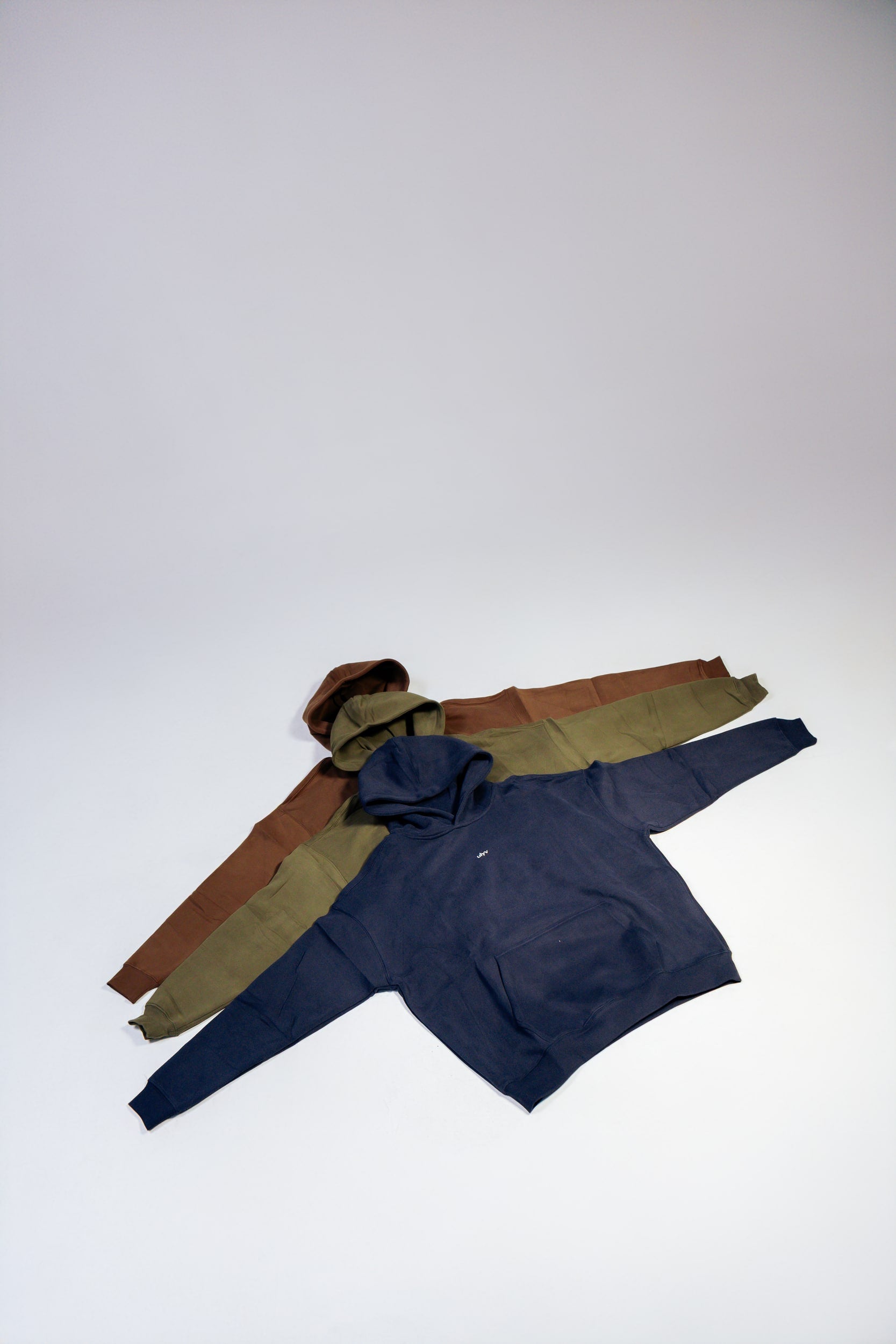 ULYV essential hoodies arranged in navy olive and brown