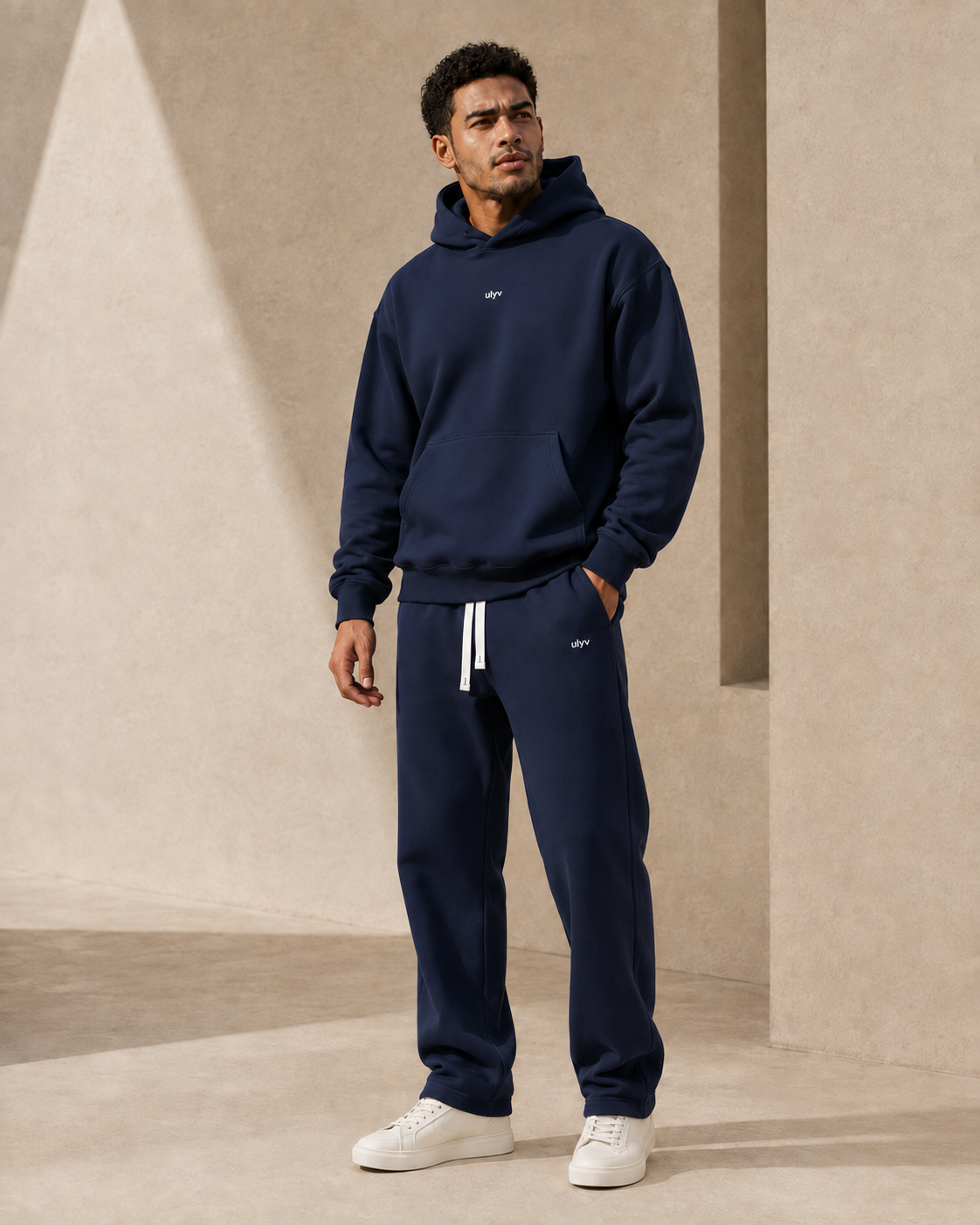 Adult model in the ULYV Navy matching hoodie and sweatpants, full length view