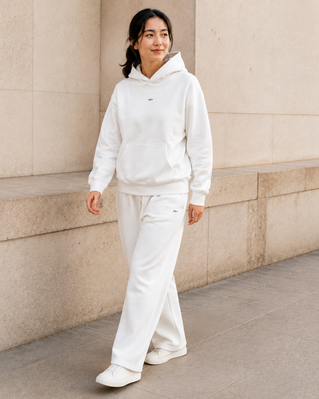Adult model in the ULYV White matching hoodie and sweatpants, full length view
